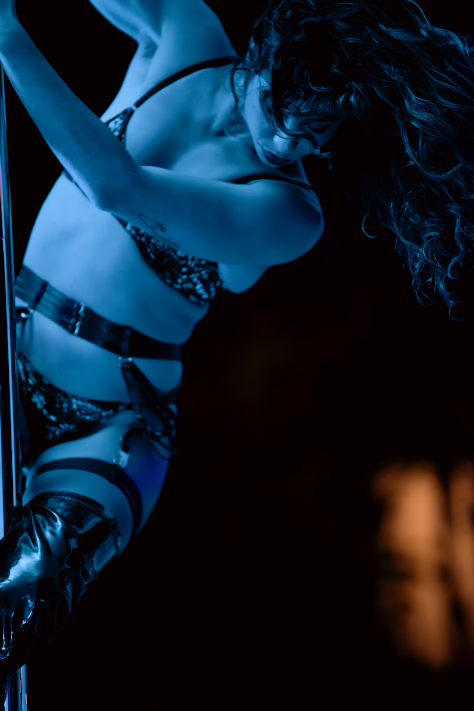Pole artistry in blue light - hair flowing